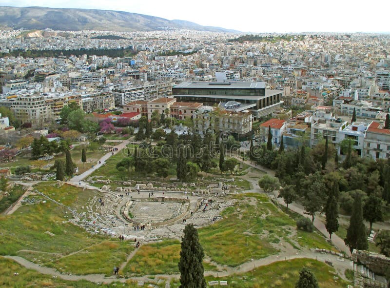 Teatro de las ruinas de Dionysus y el edificio moderno de la opinión del museo de la acrópolis de la acrópolis de Atenas, Grecia foto de archivo Teatro de las ruinas de Dionysus y el edificio moderno de la opinión del museo de la acrópolis de la acrópolis de Atenas, Grecia foto de archivo