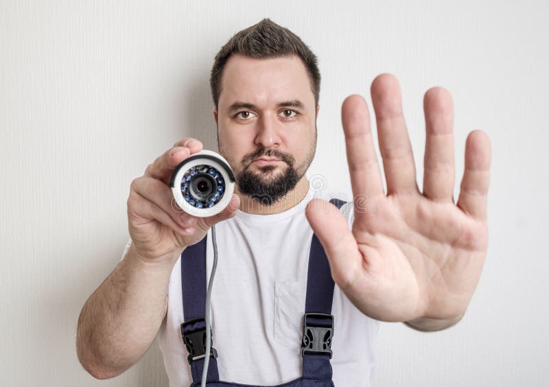 Technician with CCTV Security Camera Showing Stop Gesture Stock Photo
