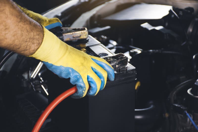 Technician Clamping the Charger Cable To the Car Battery Stock Photo