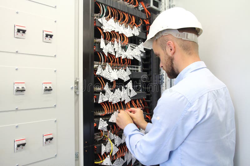 Technician in communications box connecting opto fibers royalty free stock images