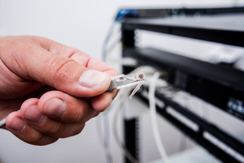 Technician Connecting Network Cables To Switches. Connecting Cables