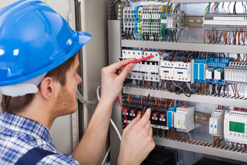 Technician examining fusebox with multimeter probe