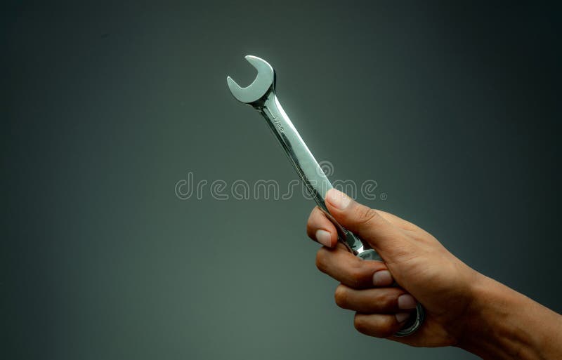 Technician hand holding chrome wrench. Plumber or mechanic technician work with spanner in hand. Mechanic tools. Service and