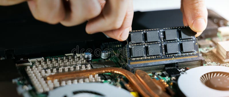 Technician installing ram memory module in laptop motherboard. computer hardware upgrade. copy space royalty free stock photos