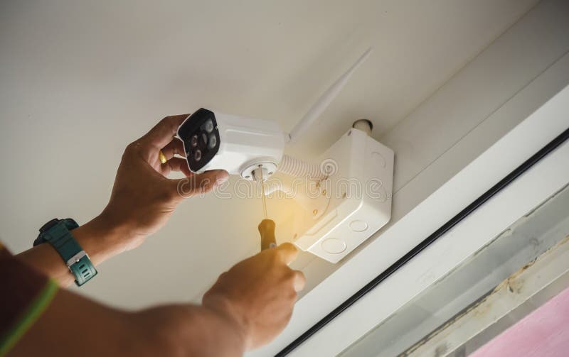 Technician installing wireless CCTV camera by screwed for home security system and installed w royalty free stock images