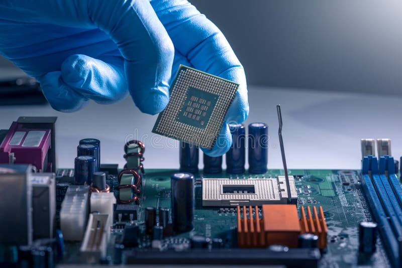 The technician is laying a CPU on the socket of the computer motherboard. the concept of computer, service, electronics, hardware royalty free stock photos