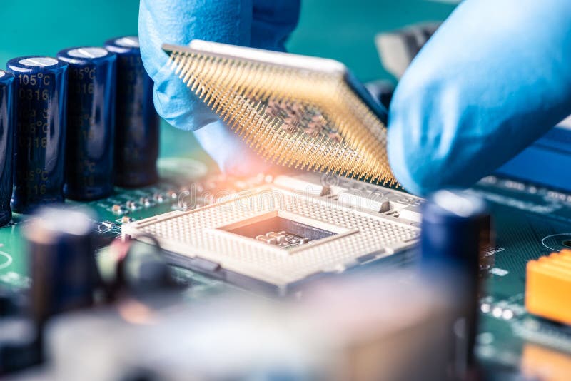The technician is laying a CPU on the socket of the computer motherboard. royalty free stock images