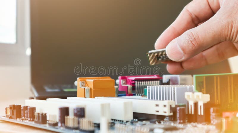 Technician is putting the CPU on the socket of the computer motherboard. concept of computer hardware. repairing upgrade and royalty free stock photos