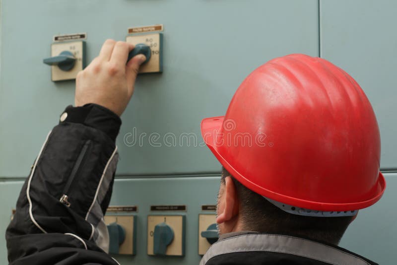 Technician with Red Helmet Turn Off the Power Switch Stock Photo