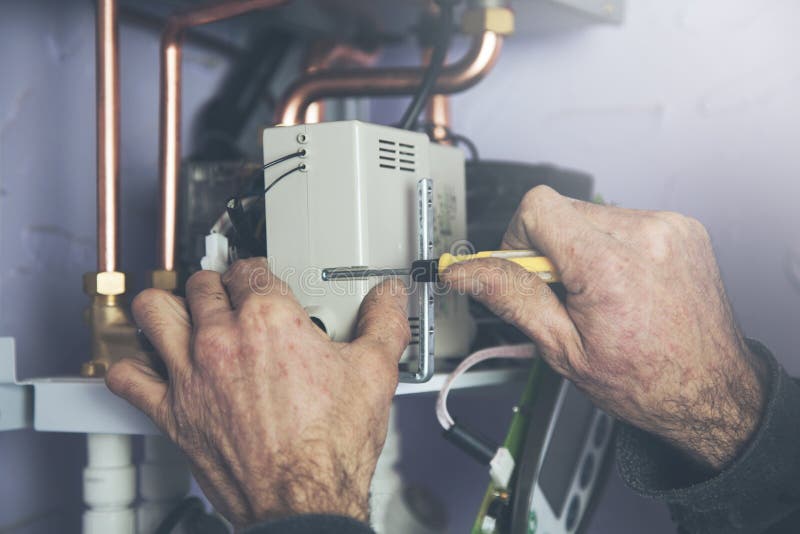 Technician Servicing the Gas Boiler for Hot Water and Heating Stock