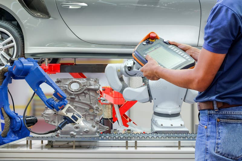 Technician use wireless remote for setting program for control industrial robot stock photography Technician use wireless remote for setting program for control industrial robot stock photography