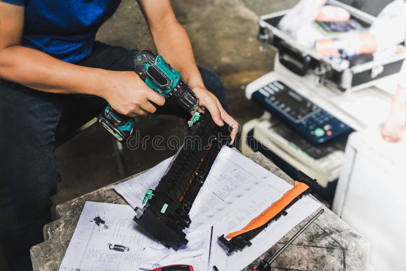 Technician is using an electric drill to tighten the drum`s nuts to disassemble it, repair it and clean it royalty free stock photography