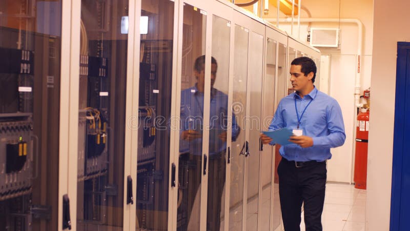 Technician walking in server room stock footage