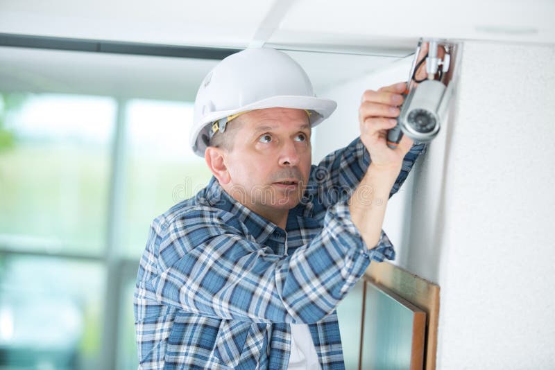 Technician Worker Installing Video Surveillance Camera on Wall Stock