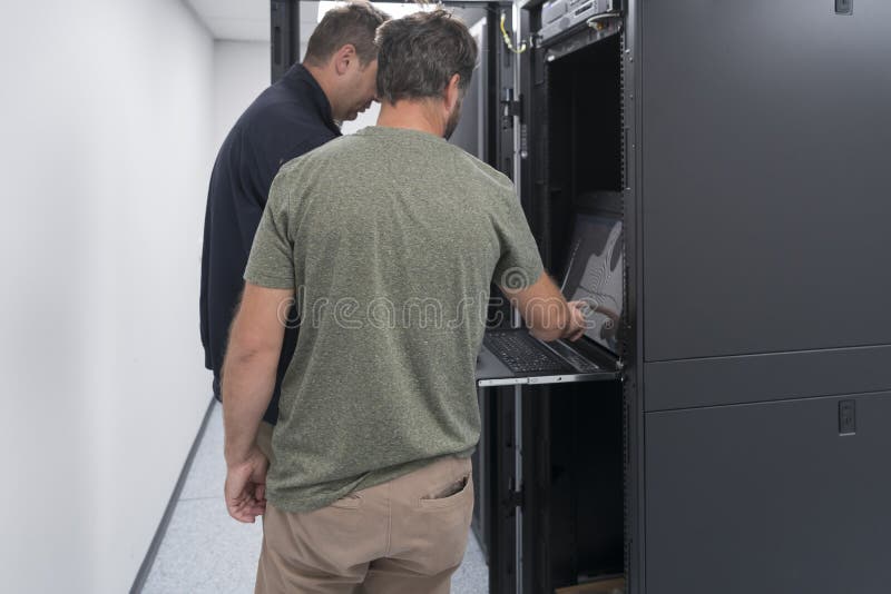 Technicians team updating hardware inspecting system performance in super computer server room or cryptocurrency mining stock images