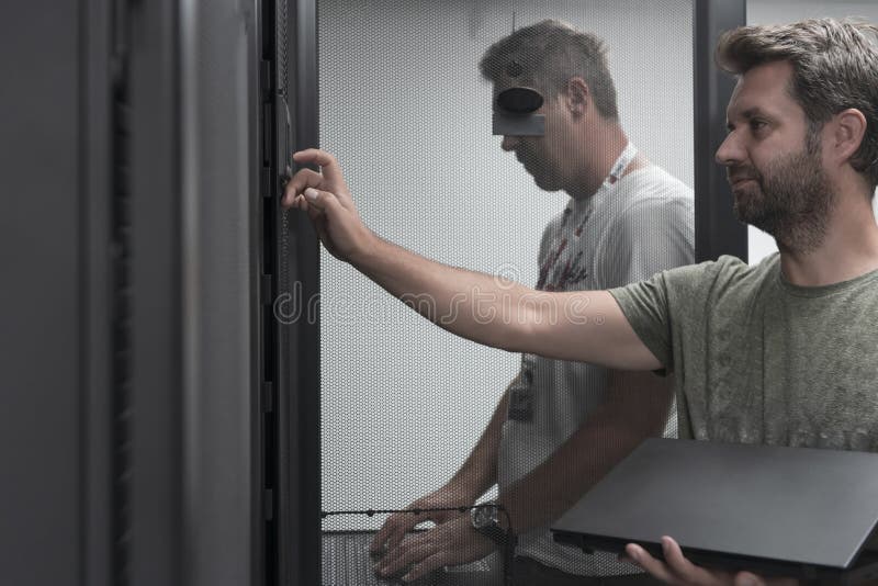 Technicians team updating hardware inspecting system performance in super computer server room or cryptocurrency mining stock photo