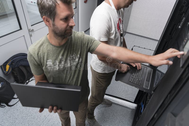 Technicians team updating hardware inspecting system performance in super computer server room or cryptocurrency mining stock photography