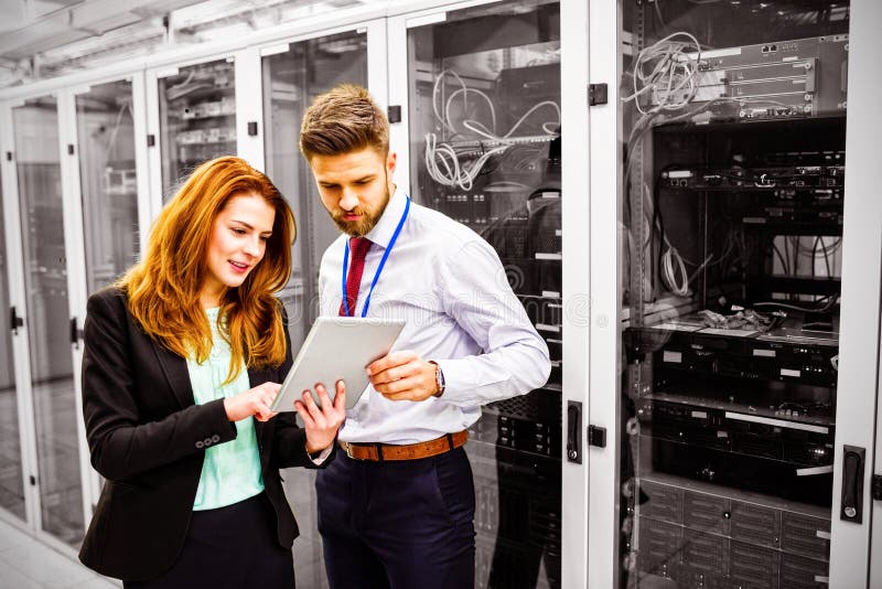Technicians using digital tablet while analyzing server royalty free stock photos Technicians using digital tablet while analyzing server royalty free stock photos