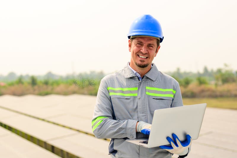 Technicien d'entretien travaillant sur une ferme à cellules solaires écologiques photos stock