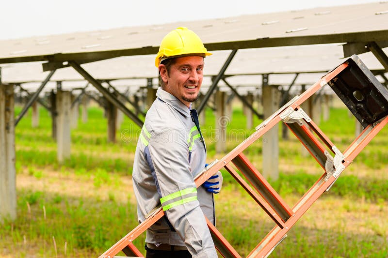 Technicien d'entretien vérifiant les panneaux solaires sur la ferme à cellules solaires images libres de droits