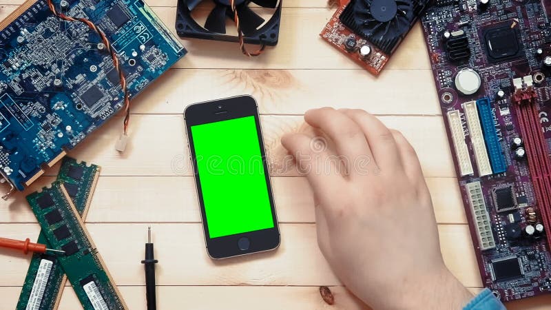 Technicien d'ordinateur de vue supérieure montrant des gestes multiples au téléphone intelligent avec l'écran vert au bureau en b banque de vidéos