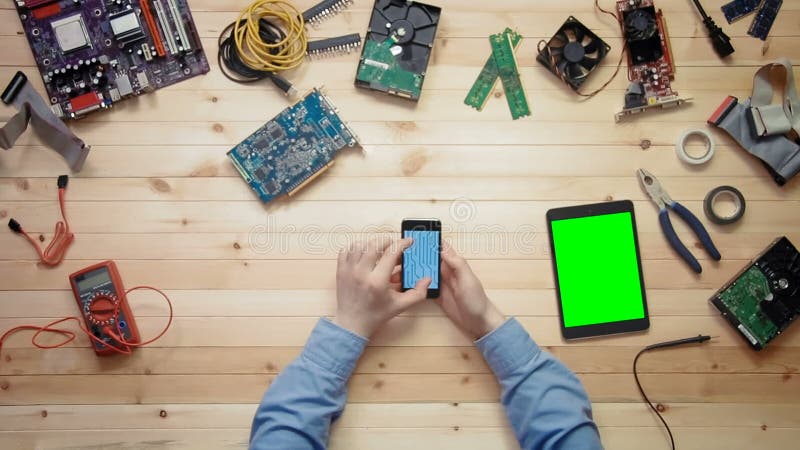 Technicien d'ordinateur de vue supérieure à l'aide du téléphone intelligent avec le contour de carte et du comprimé numérique ave banque de vidéos