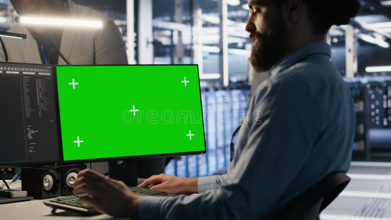 Technicien de centre de données effectuant des mises à jour logicielles à l'aide d'un ordinateur de simulation à écran vert banque de vidéos