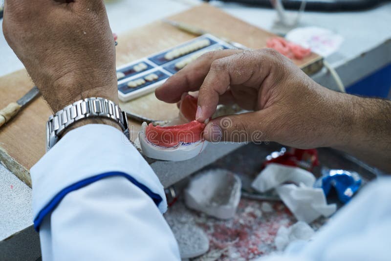 Technicien dentaire utilisant un couteau avec les implants dentaires en céramique photo libre de droits Technicien dentaire utilisant un couteau avec les implants dentaires en céramique photo libre de droits