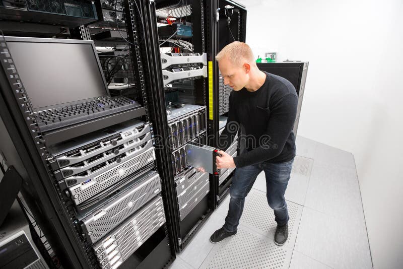 Technicien informatique Installing Blade Server dans le châssis chez Datacenter photo stock Technicien informatique Installing Blade Server dans le châssis chez Datacenter photo stock