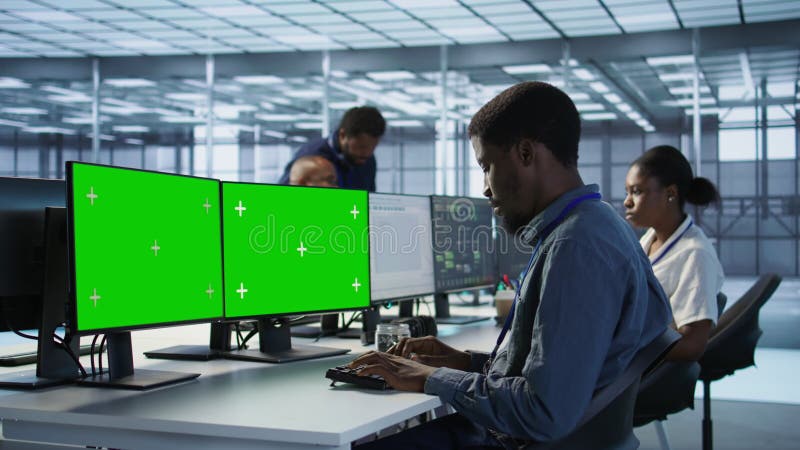 Technicien utilisant la configuration de l'ordinateur à écran vert multi-moniteur dans la batterie de serveurs clips vidéos