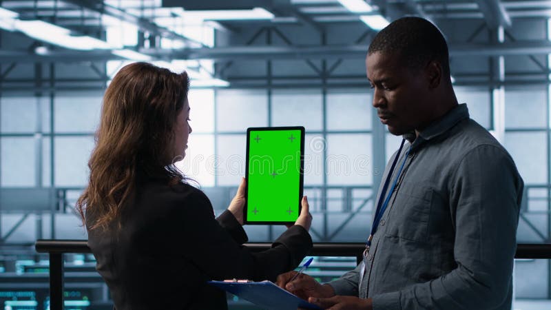 Techniciens dans le centre de données à l'aide d'une tablette à écran vert examen du matériel clips vidéos