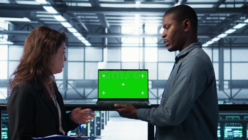 Techniciens en datacenter utilisant un ordinateur portable maquillage à écran vert banque de vidéos