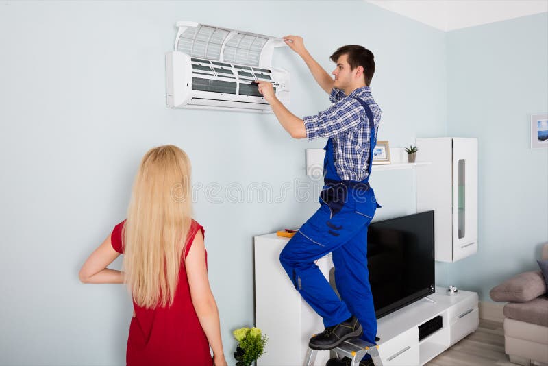 Technicus Repairing Air Conditioner thuis stock foto Technicus Repairing Air Conditioner thuis stock foto