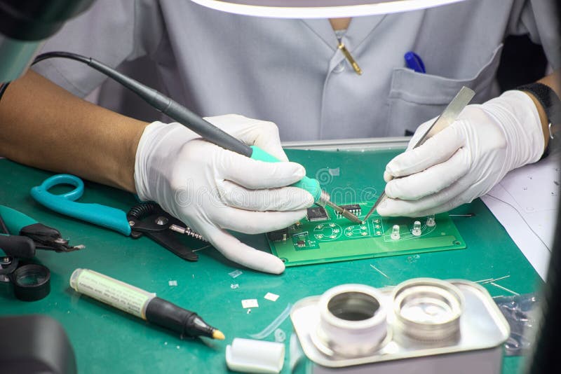 Technicus vrouwelijk met soldering om elektronicafabrikaat te lassen