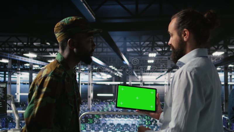 Technicy wojskowi w centrum danych używają tabletu z zielonym ekranem zbiory
