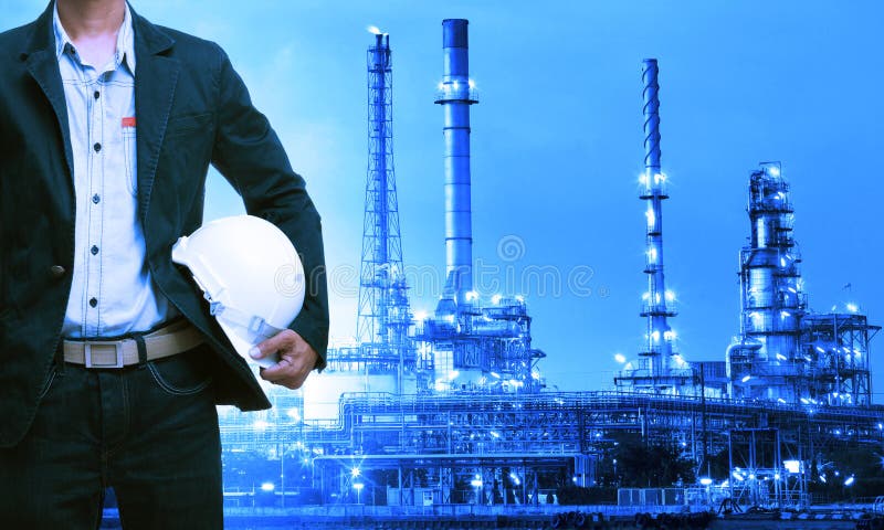 Techniekmens en veiligheidshelm die zich tegen olieraffinaderij bevinden