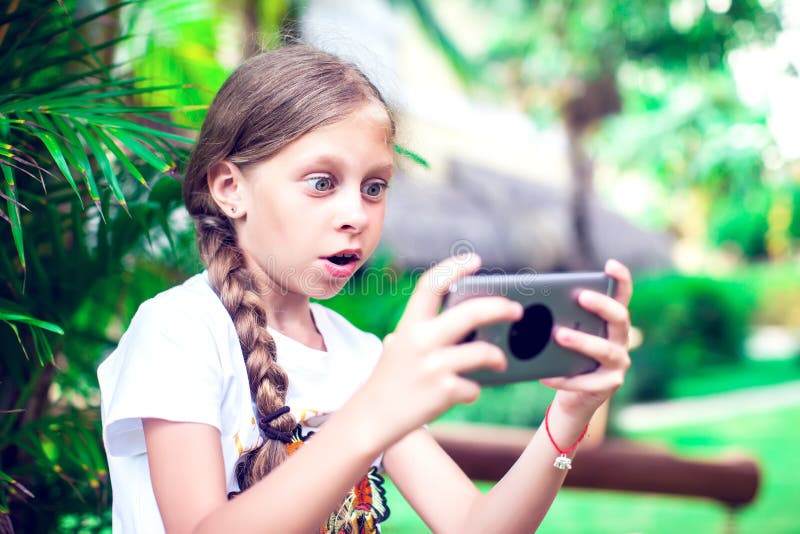Technologie und Leutekonzept - glückliches lächelndes Mädchen, das smartph verwendet lizenzfreies stockbild Technologie und Leutekonzept - glückliches lächelndes Mädchen, das smartph verwendet lizenzfreies stockbild