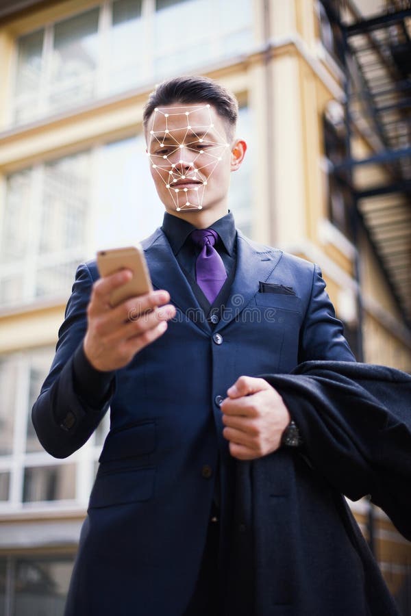 The technology of computer recognition of persons and the concept of artificial intelligence. The face of a young businessman and stock images