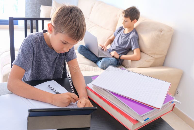 Technology, education, online learning, distance learning at home. Boy start doing mathematics homework with books and