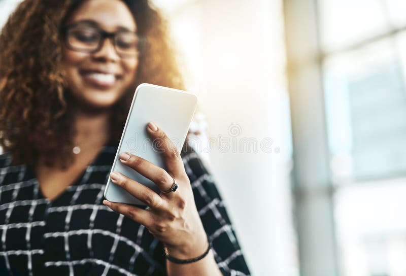 Technology helps her get everything done in one go. an unrecognizable businesswoman using a smartphone in a modern stock photography