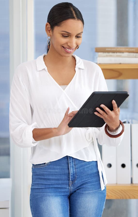 Technology makes life so much easier. a young businesswoman using a digital tablet in a modern office. stock images