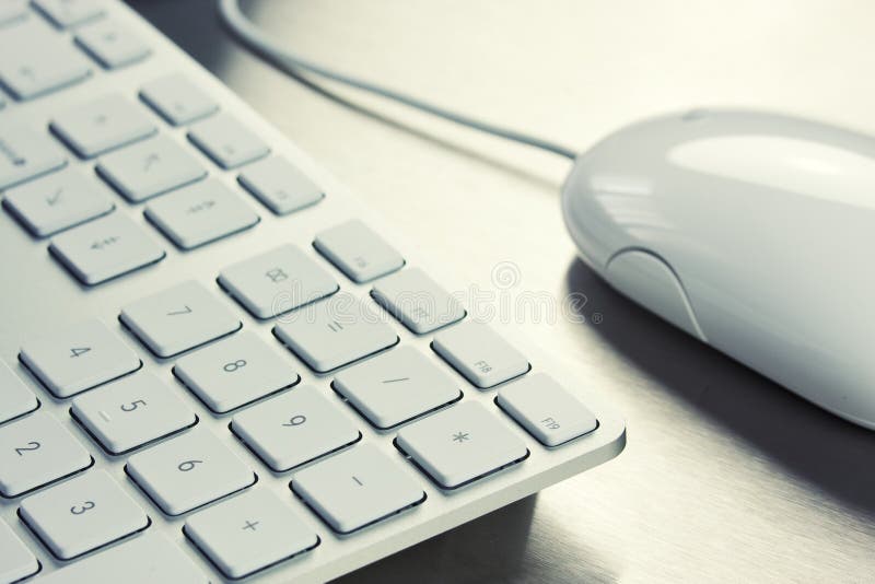 Close-up of White keyboard and mouse on metal background. Close-up of White keyboard and mouse on metal background