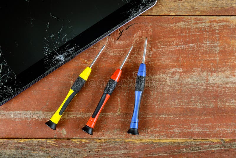 Tecnico che ripara dentro della compressa dal cacciavite nella tecnologia di riparazione elettronica del telefono cellulare immagine stock libera da diritti Tecnico che ripara dentro della compressa dal cacciavite nella tecnologia di riparazione elettronica del telefono cellulare immagine stock libera da diritti