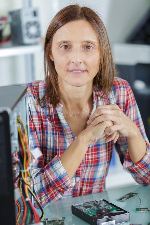 Tecnico femminile del pc che esamina macchina fotografica fotografia stock Tecnico femminile del pc che esamina macchina fotografica fotografia stock