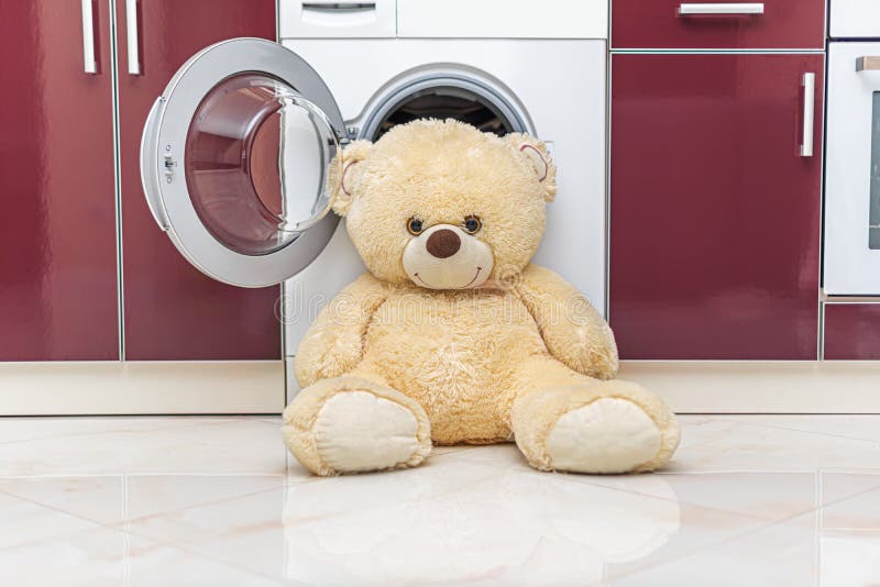 Teddy Bear is Getting Ready To Be Washed in the Washing Machine. Stock