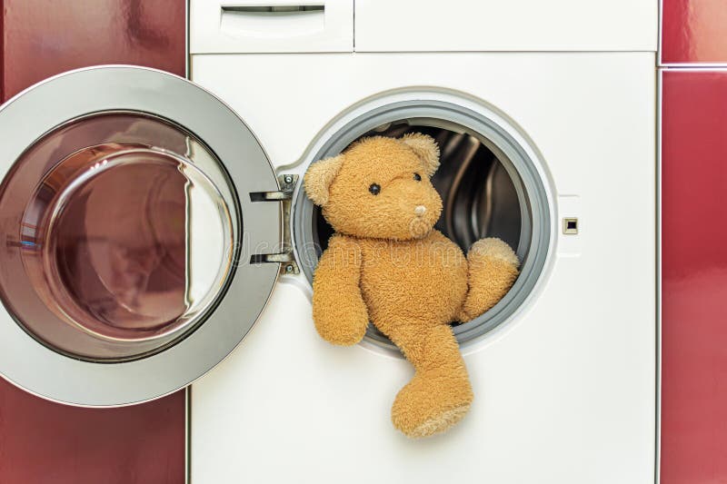 Teddy Bear is Getting Ready To Be Washed in the Washing Machine. Stock