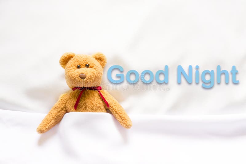 Teddy Bear se situant dans le lit blanc avec le message et le x22 ; Bonne nuit et x22 ; photos libres de droits Teddy Bear se situant dans le lit blanc avec le message et le x22 ; Bonne nuit et x22 ; photos libres de droits