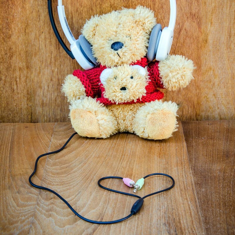 Teddy Bear with White Headphone and Heart Shaped Cables on Wood Stock