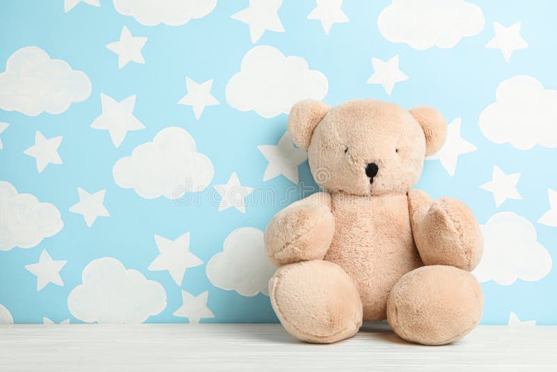 Teddy beer op witte houten tafel vlakbij de muur met geschilderde lucht, ruimte voor tekst Binnenin babykamer stock afbeeldingen Teddy beer op witte houten tafel vlakbij de muur met geschilderde lucht, ruimte voor tekst Binnenin babykamer stock afbeeldingen