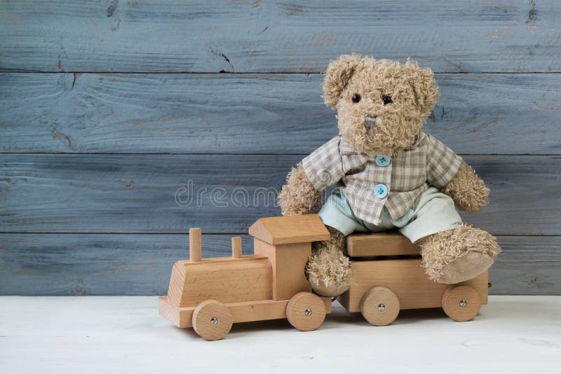 Teddybär, der auf dem hölzernen Zug des Spielzeugs, hölzerner Hintergrund sitzt stockfotos Teddybär, der auf dem hölzernen Zug des Spielzeugs, hölzerner Hintergrund sitzt stockfotos